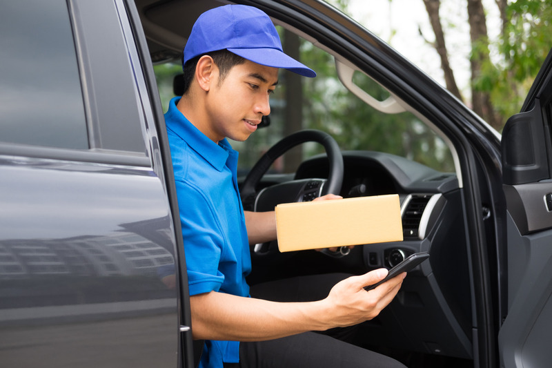 Delivery driver driving car with packages