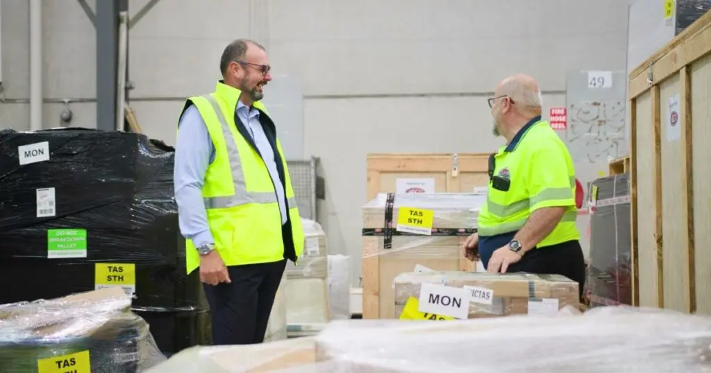 Warehouse personnel engaged in a logistics discussion, optimizing operations for efficiency