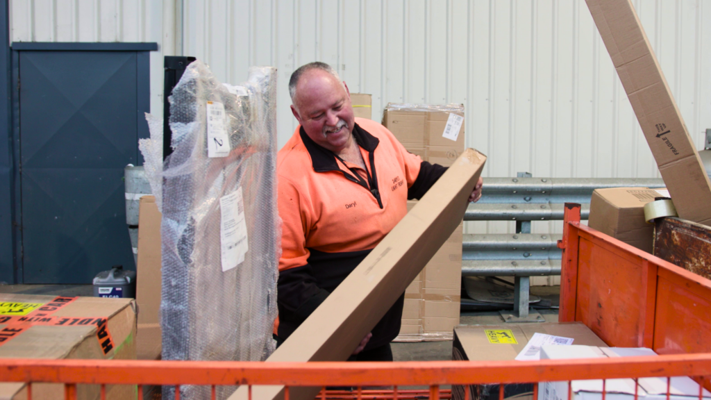 Delivery Man Organizing and Categorizing Packages in a Logistics Facility