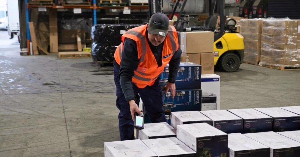 delivery driver scanning boxes preparing for dispatch