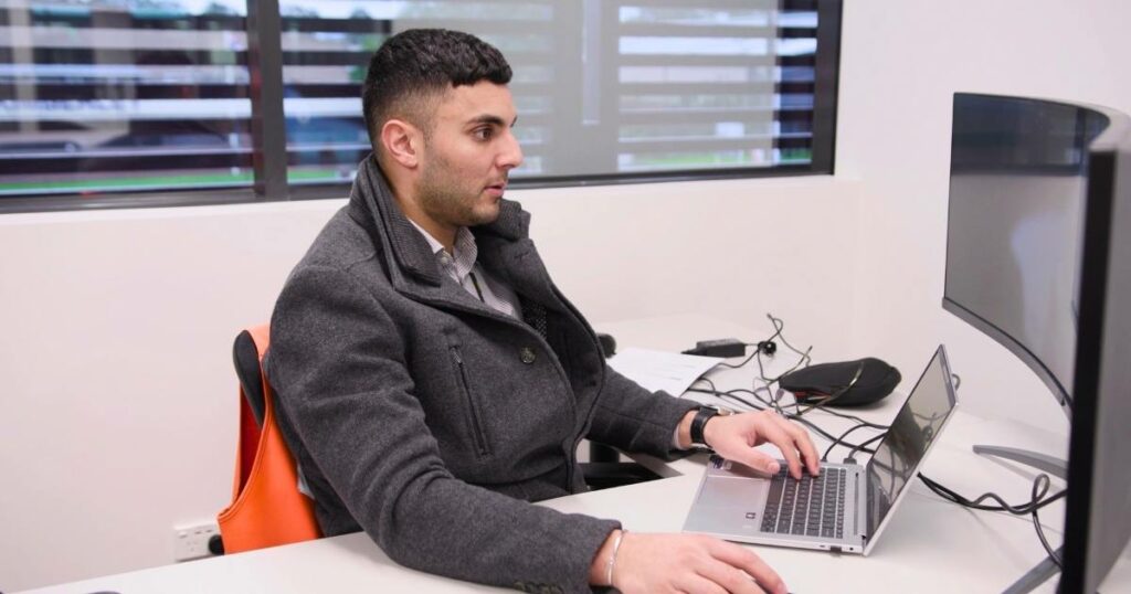 man meticulously reviewing records on a computer, exemplifying the role of logistics software in precise logistics management and data analysis