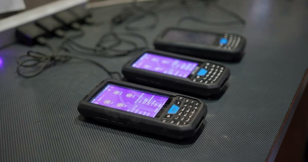 A row of digital scanners neatly lined up, essential tools in logistics and inventory management