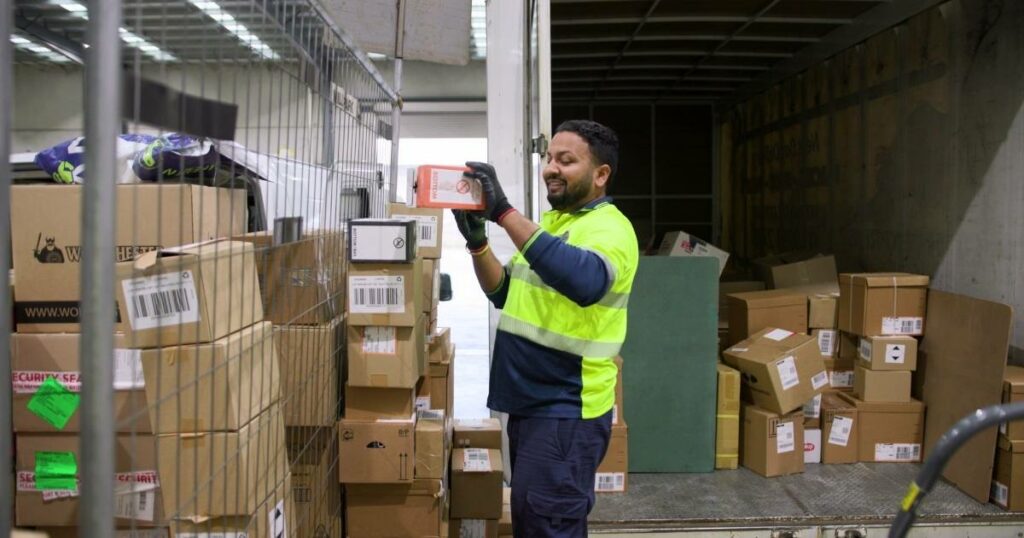 A man inspecting a package's sticker, ensuring accuracy and precision in logistics handling