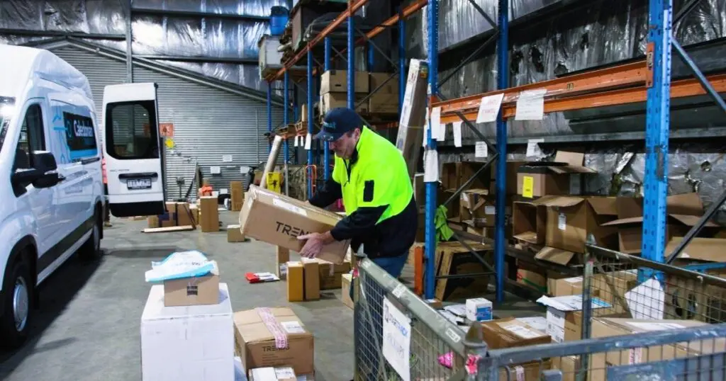 delivery driver loading packages on truck managing truckload logistics