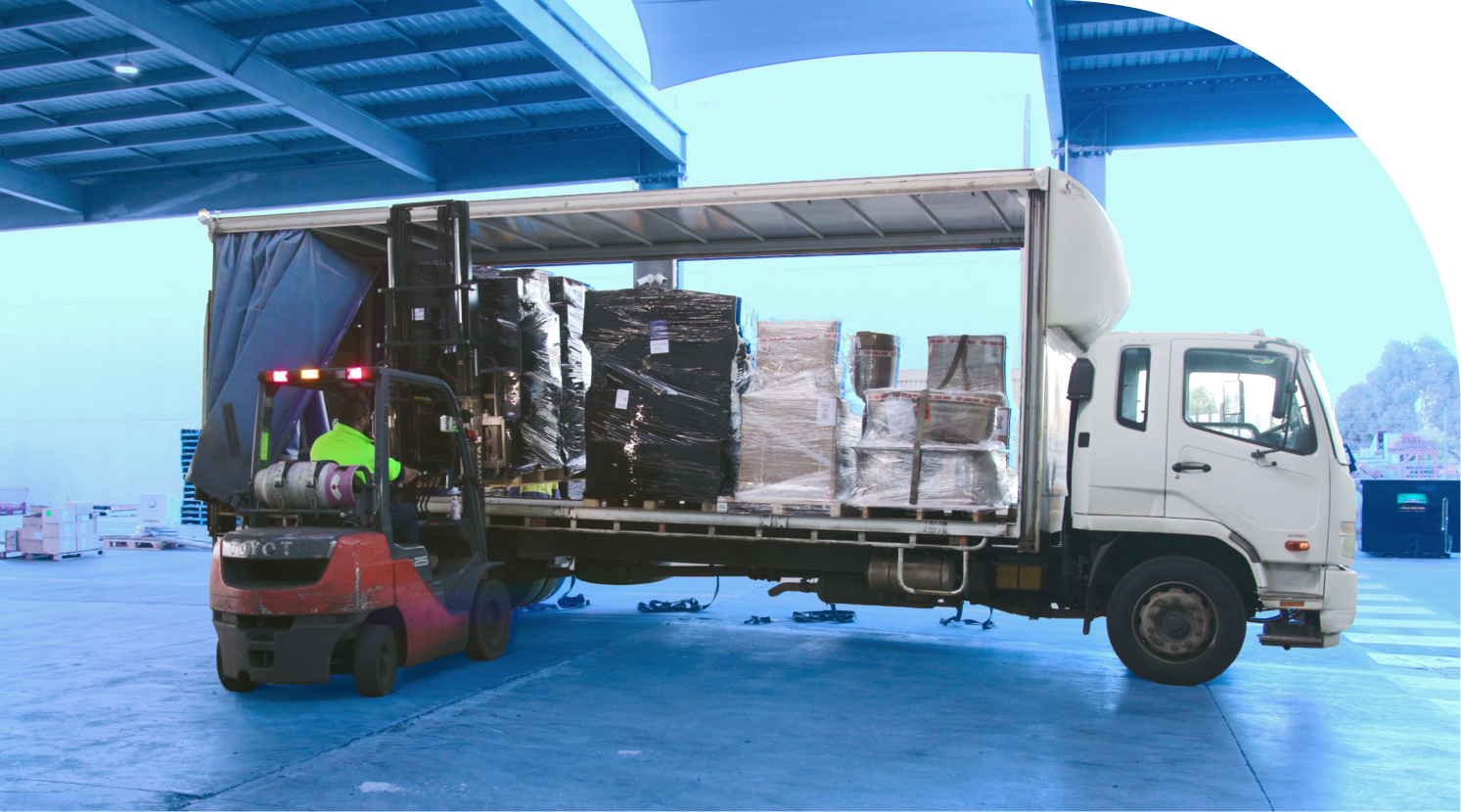 industrial forklift efficiently loads cargo onto a delivery truck, showcasing efficient logistics operations