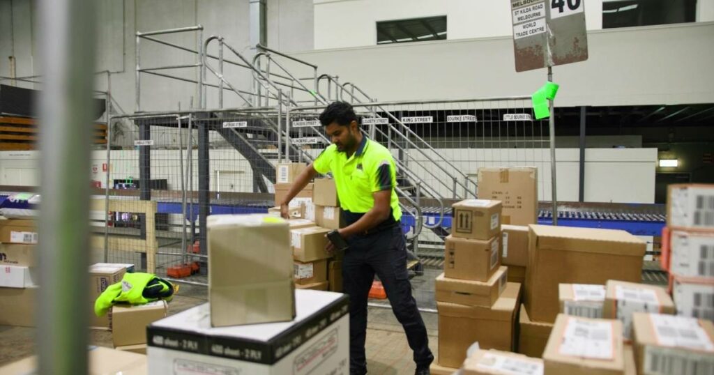 warehouse employee scanning barcode packages sorting out boxes for delivery