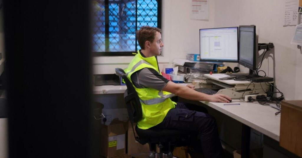 a man using desktop computer for logistics software, streamlining supply chain management