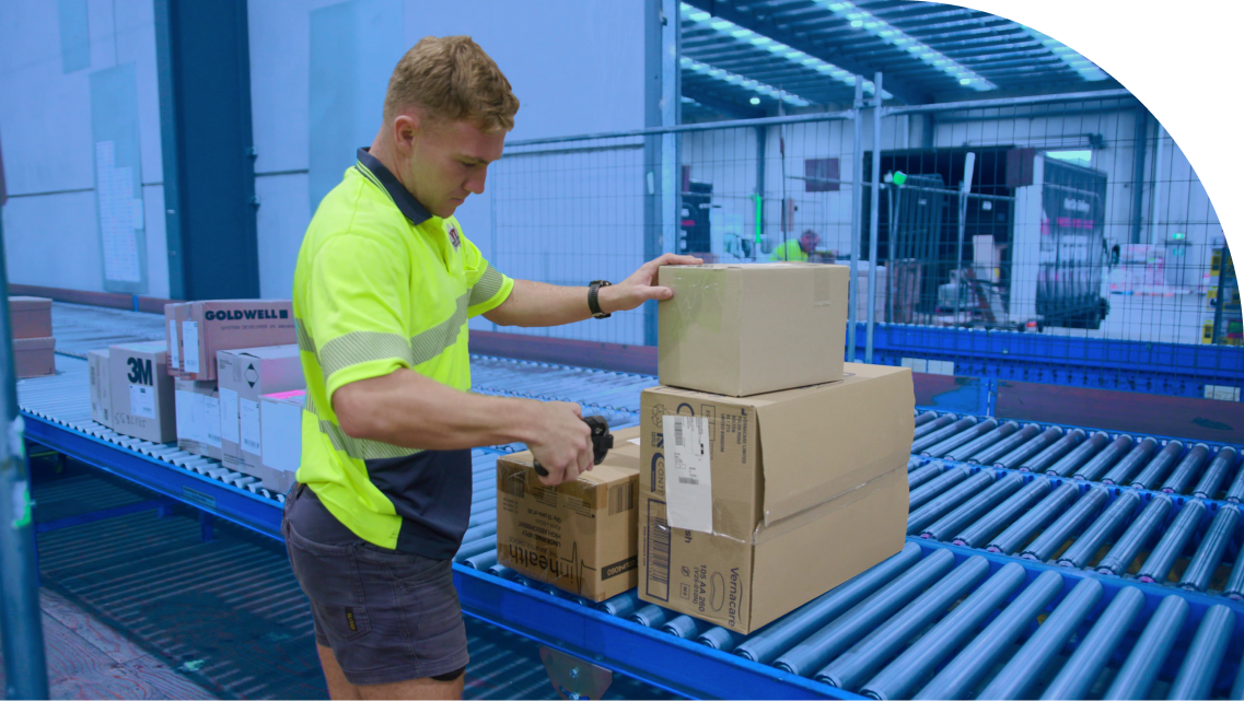 man diligently scanning packages, showcasing the integration of logistics software for efficient logistics management and tracking
