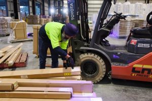 man efficiently scanning packages with logistics software, ensuring precise tracking and management of shipments within the supply chain