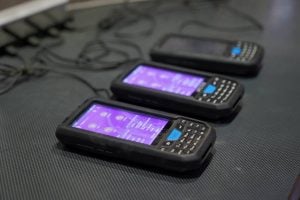 A row of digital scanners neatly lined up, essential tools in logistics and inventory management