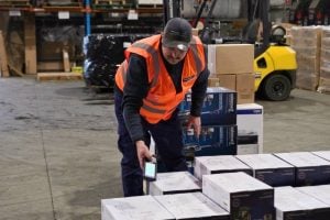 delivery driver scanning boxes preparing for dispatch