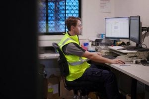 a man using desktop computer for logistics software, streamlining supply chain management